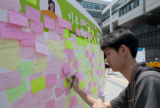 지난 5월 31일 서울대 학생회관에서 학생들이 ‘기부는 □□□ 다’ 이벤트에 참여해 메시지를 적고 있다