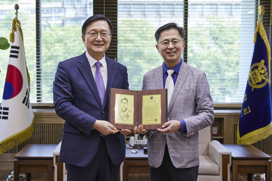 유홍림 총장과 송재용 교수가 기념 촬영을 하고 있다.